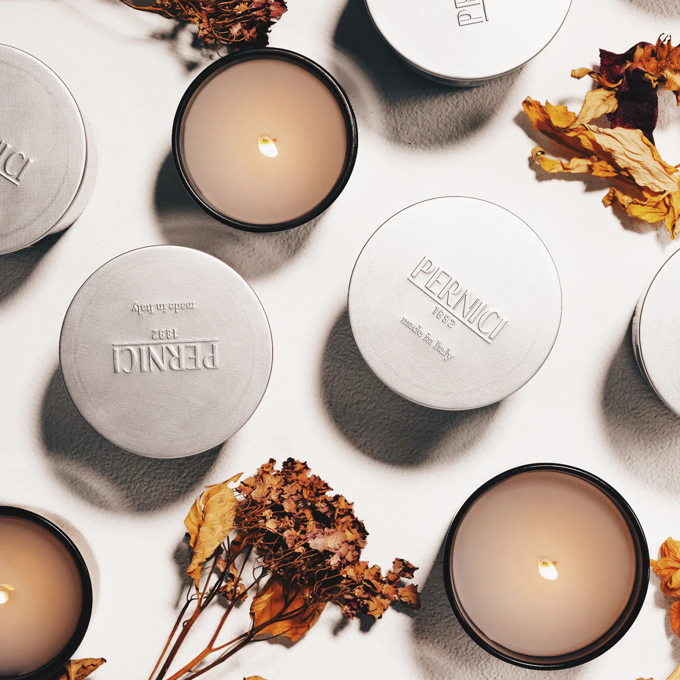 a group of candles and dried flowers